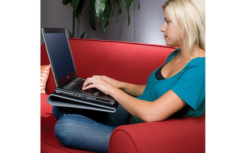 Woman sat on a sofa using the Targus Laptop Cooling Pad 15