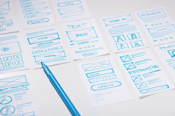Wireframes of multiple application designs displayed on table