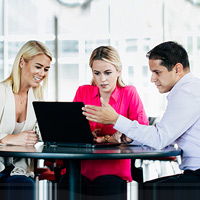 Team collaborating around notebook at office table