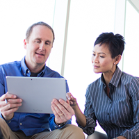 Employee showing coworker view of their tablet in collaboration