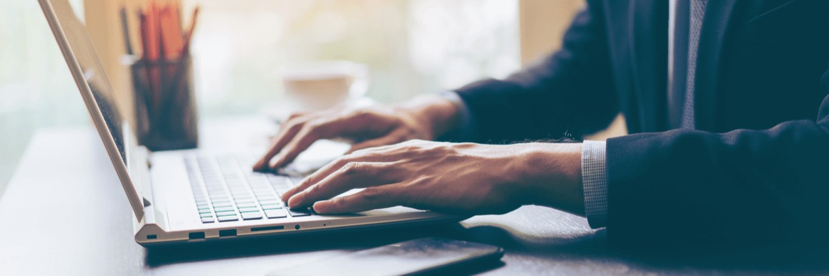 Close up of businessman typing on laptop keyboard