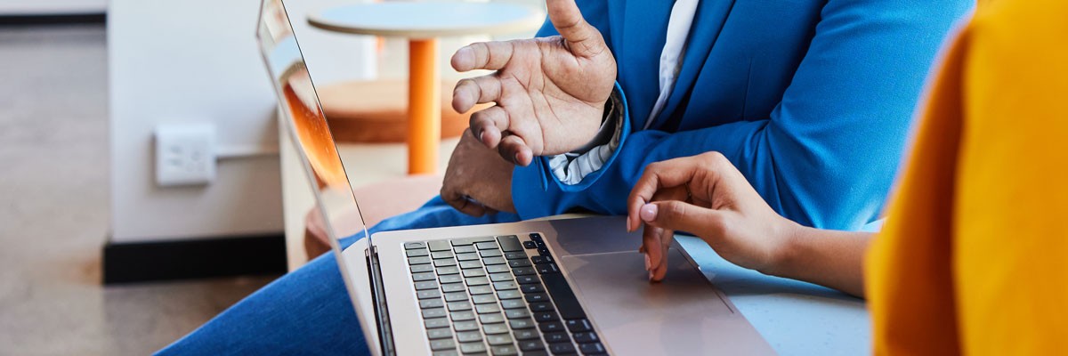 Side view of laptop being used by two business colleagues 