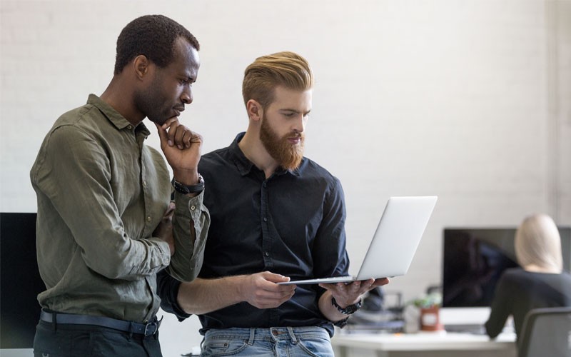 Two men working together at laptop