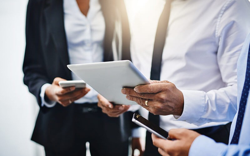 Three business professionals check their email from their smart device