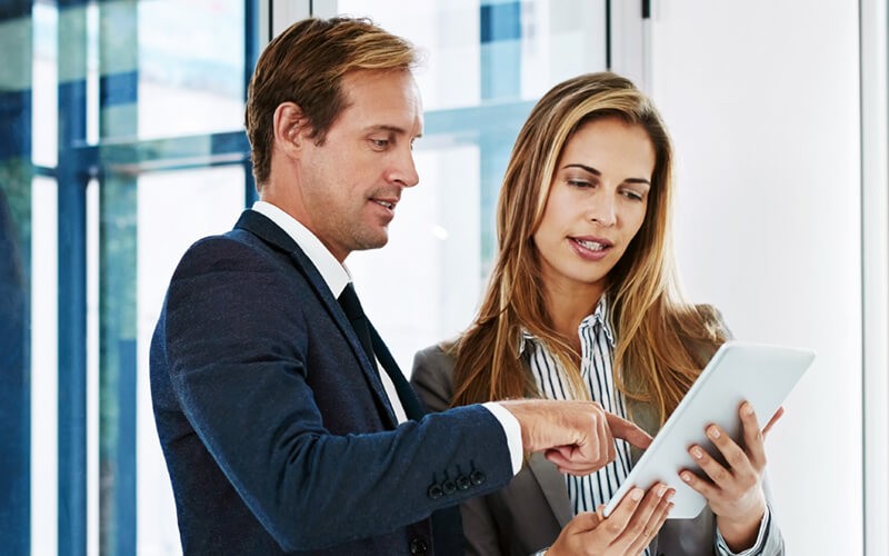 Two business professionals on tablet discussing cloud strategy