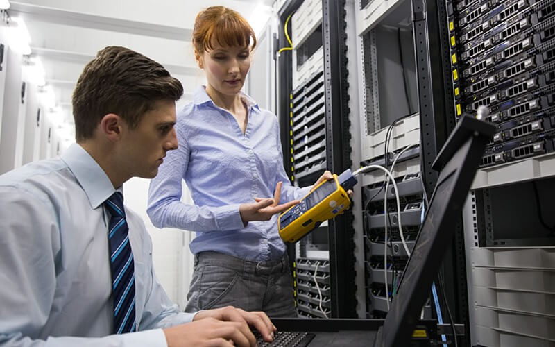 IT engineers assess data center issues with laptop computer