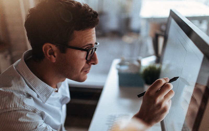 Business professional using touch pen on desktop computer screen