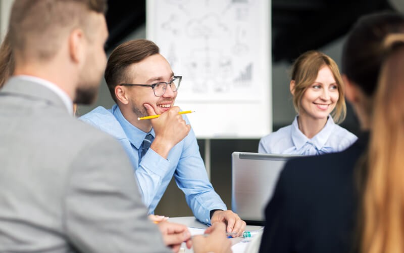 Business colleagues gathered around in collaborative meeting