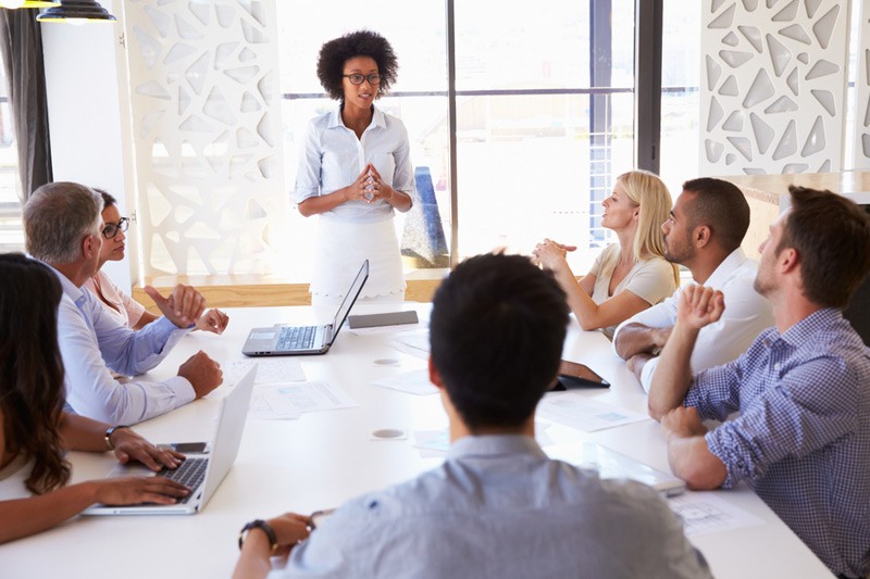 African american business woman addressing conference room of people.