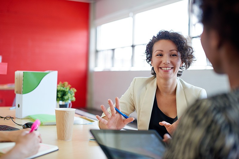 Business woman has discussion with employee on tablet computer.