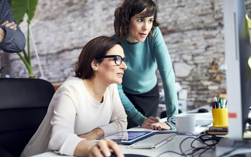 Team collaborating around desktop computer