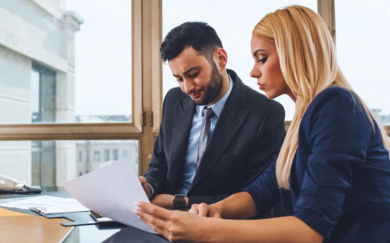 Two business professionals meet over laptop computer